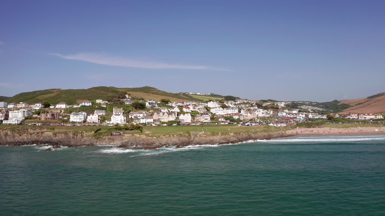 órbita aérea baja de una ciudad costera en un día de verano perfecto