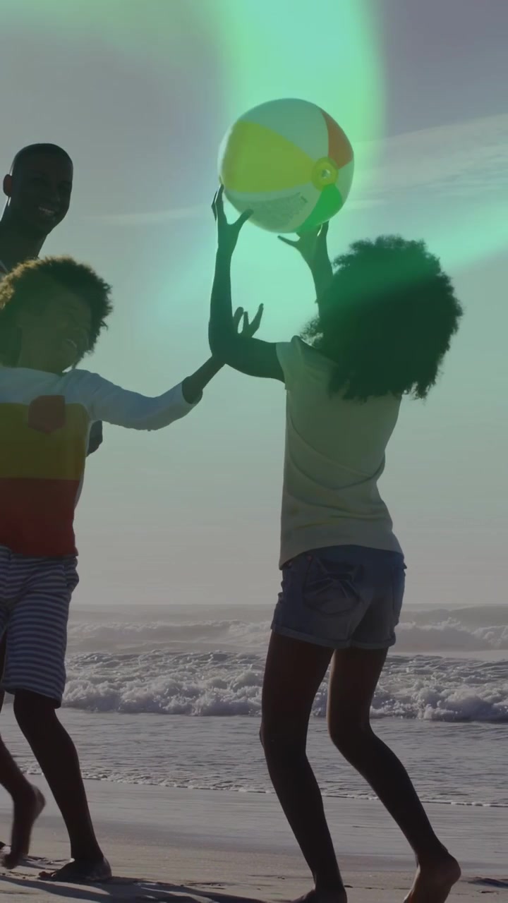 Vertical video: Man walking sand, guiding, girl jumping catching aloft ball, boy running for health