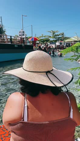 una mujer relajándose junto a una piscina.