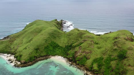 aerial zoom out of rocky white sand beach at bukit merese lombok on cloudy day