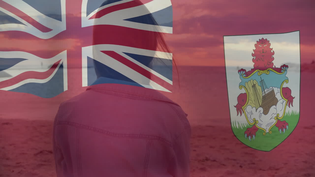 Persona in piedi sulla spiaggia al tramonto, con animazione della Union Jack e dello stemma delle Bermuda