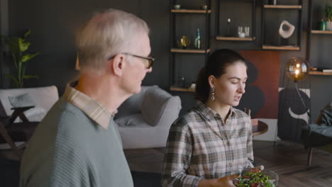 Glückliche-Familie,-Die-Neben-Dem-Tisch-Im-Wohnzimmer-Steht,-Redet-Und-Isst-Zusammen