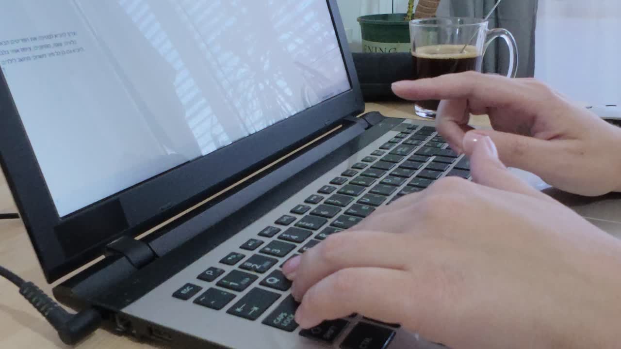 Detailed close-up shot of hands in motion, typing on a laptop keyboard