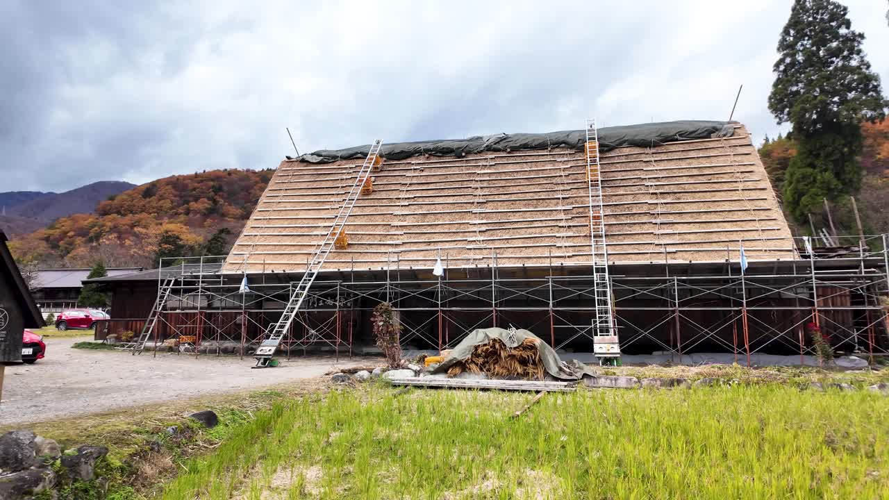 Scaffolding set up for the restoration of a gasshō-zukuri roof in Shirakawa-go. pan right shot