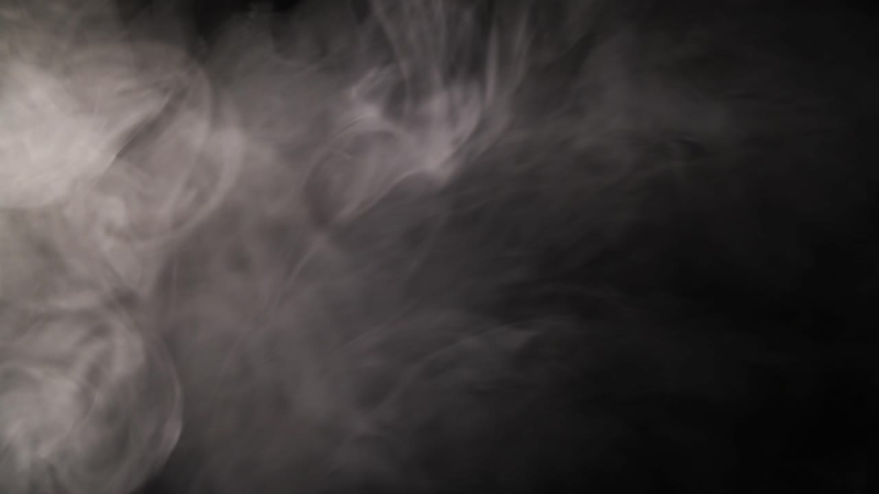 Fumo bianco che vortica e si dissolve su sfondo nero