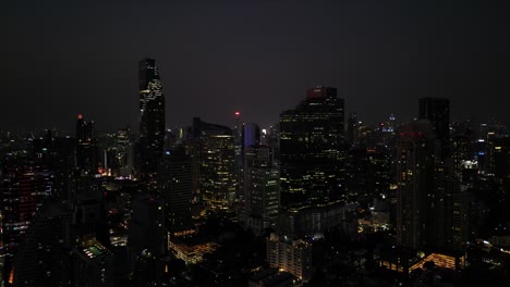 Impressive-and-awe-inspiring-Bangkok-skyline-at-night,-with-stunning-drone-footage-of-its-towering-high-rise-buildings