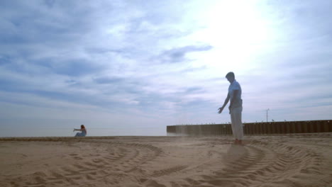 Hombre-Divirtiéndose-En-La-Playa.-Macho-Tirando-Arena-Con-El-Pie.-Vacaciones-De-Luna-De-Miel