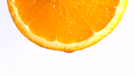 water or oils dropping on an orange slice , fruit for diet and healthy food