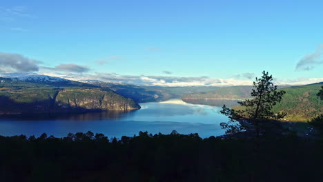 Grandiose-panoramic-view-of-large-green-valley-and-blue-calm-water-with-mountains