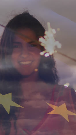 animation of flag of european union over happy biracial woman with sparklers on beach