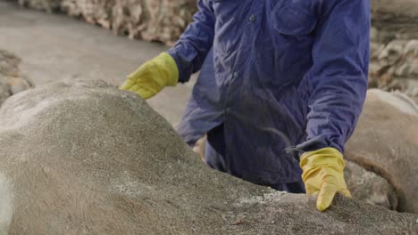 worker stacking farmed animal hides for production in a leather factory