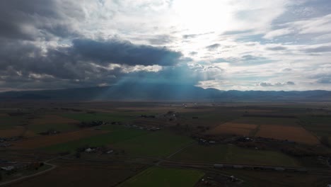 Green-and-brown-rural-farm-fields-after-a-storm-with-sunlight-coming-through