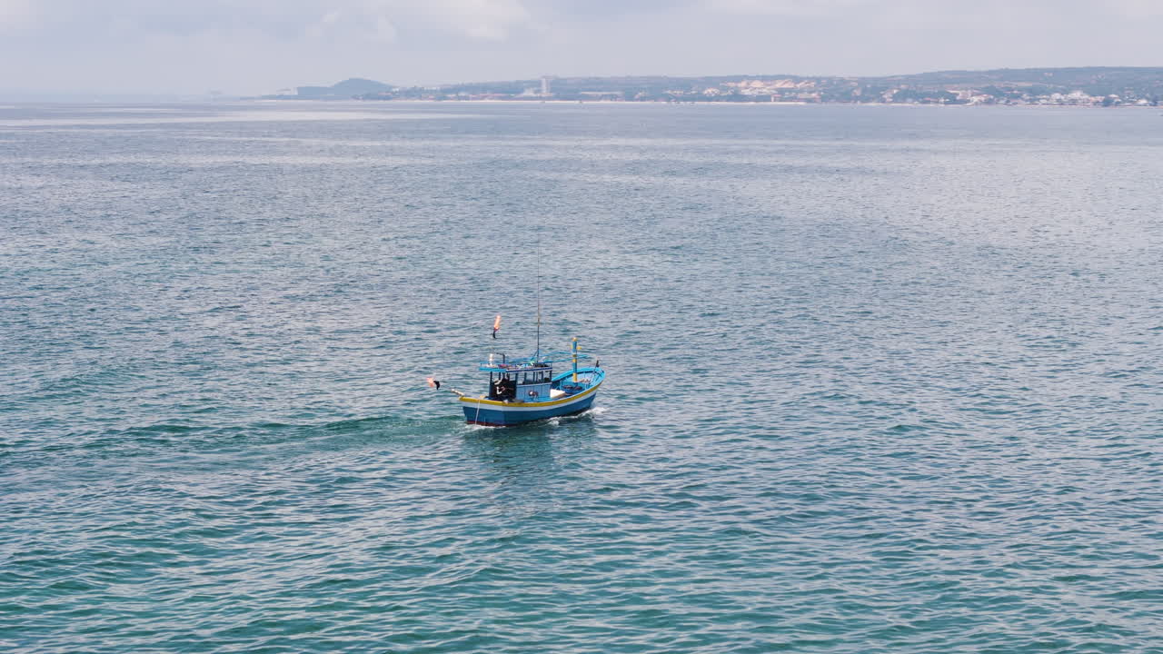 Barca da pesca asiatica locale che naviga lungo la costa del Vietnam, ripresa aerea con inseguimento