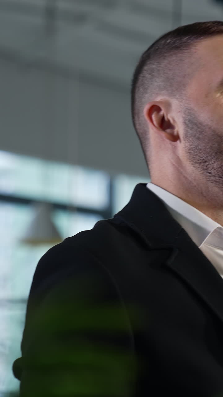 Smart young man have a phone call. Handsome confident businessman dealing with phone. Vertical video