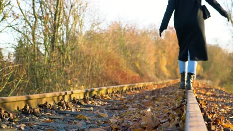 woman balancing on rails with stylish boots during outdoor adventure