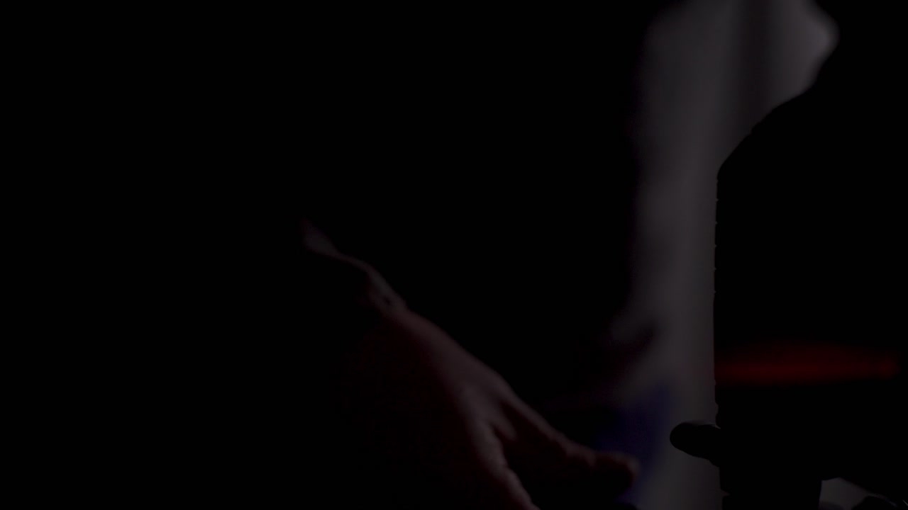 persona con un puntero láser rojo en la oscuridad