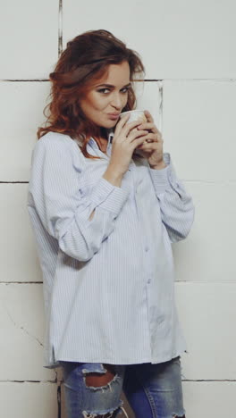 model drinking coffee in studio. young adorable woman enjoying her warm cup of coffee