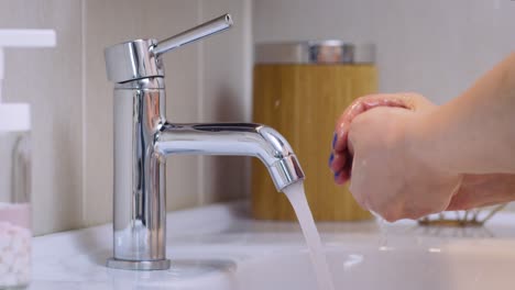 lavarse y limpiarse las manos con jabón antibacteriano y agua espumosa para eliminar virus y gérmenes en el baño a cámara lenta