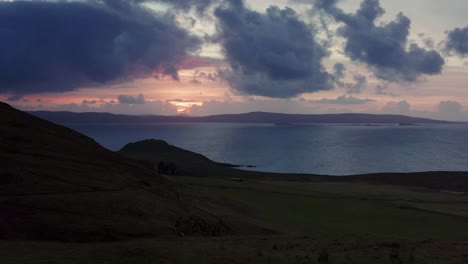 Aerial-Drone-sunset-flyover-traveller-and-fields-near-Uig-Skye-Scotland-Autumn