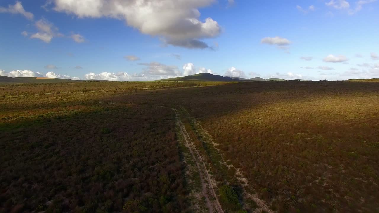 vista aérea de un camino de tierra que serpentea a través de un terreno montañoso