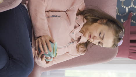 Vertical-video-of-The-woman-who-consumes-a-hot-drink-in-front-of-the-window.