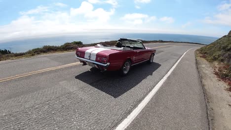 a red and white ford mustang convertible driving