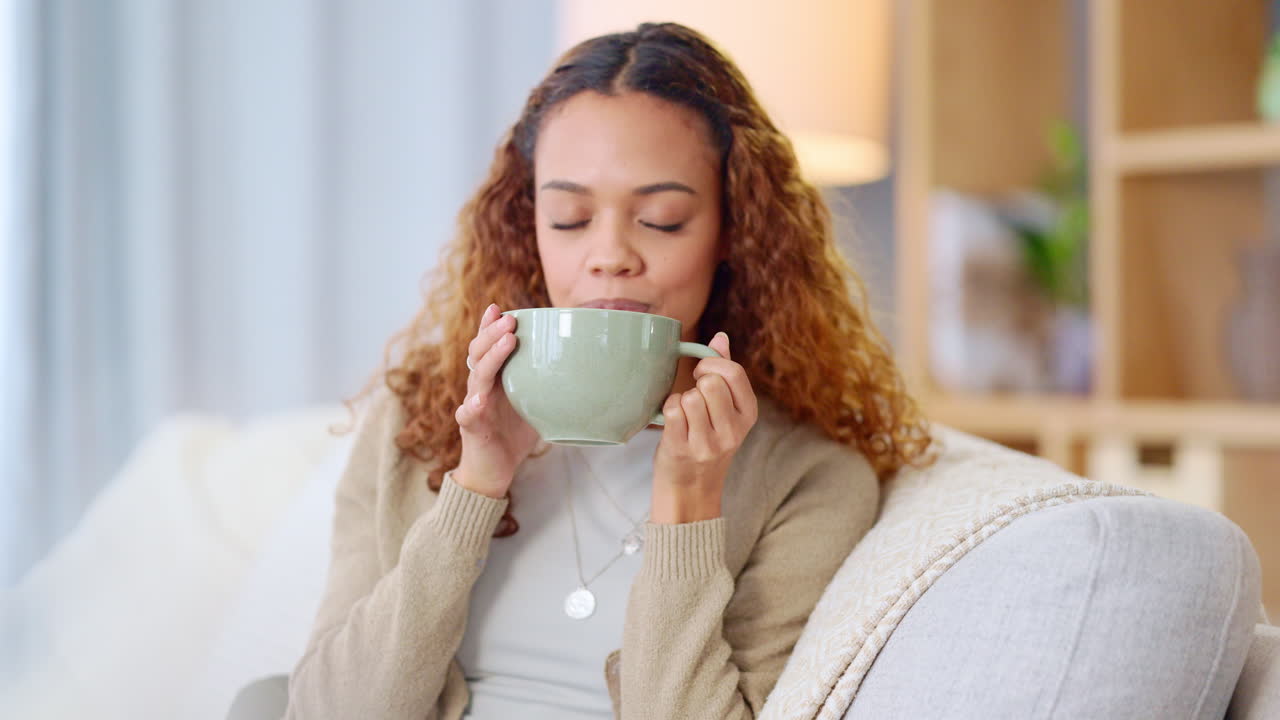 Woman drinking a hot cup of tea or coffee at home