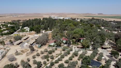 slide aéreo à direita foto de drone de uma vista panorâmica do kibutz sde-boker e da área em torno dele, cheio de árvores, arbustos, campos, trilhas, edifícios e casas