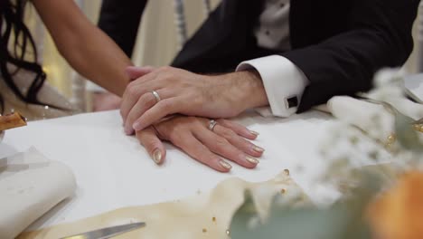 Slow-motion-shot-of-a-newly-married-couple-placing-their-hands-onto-of-eachother