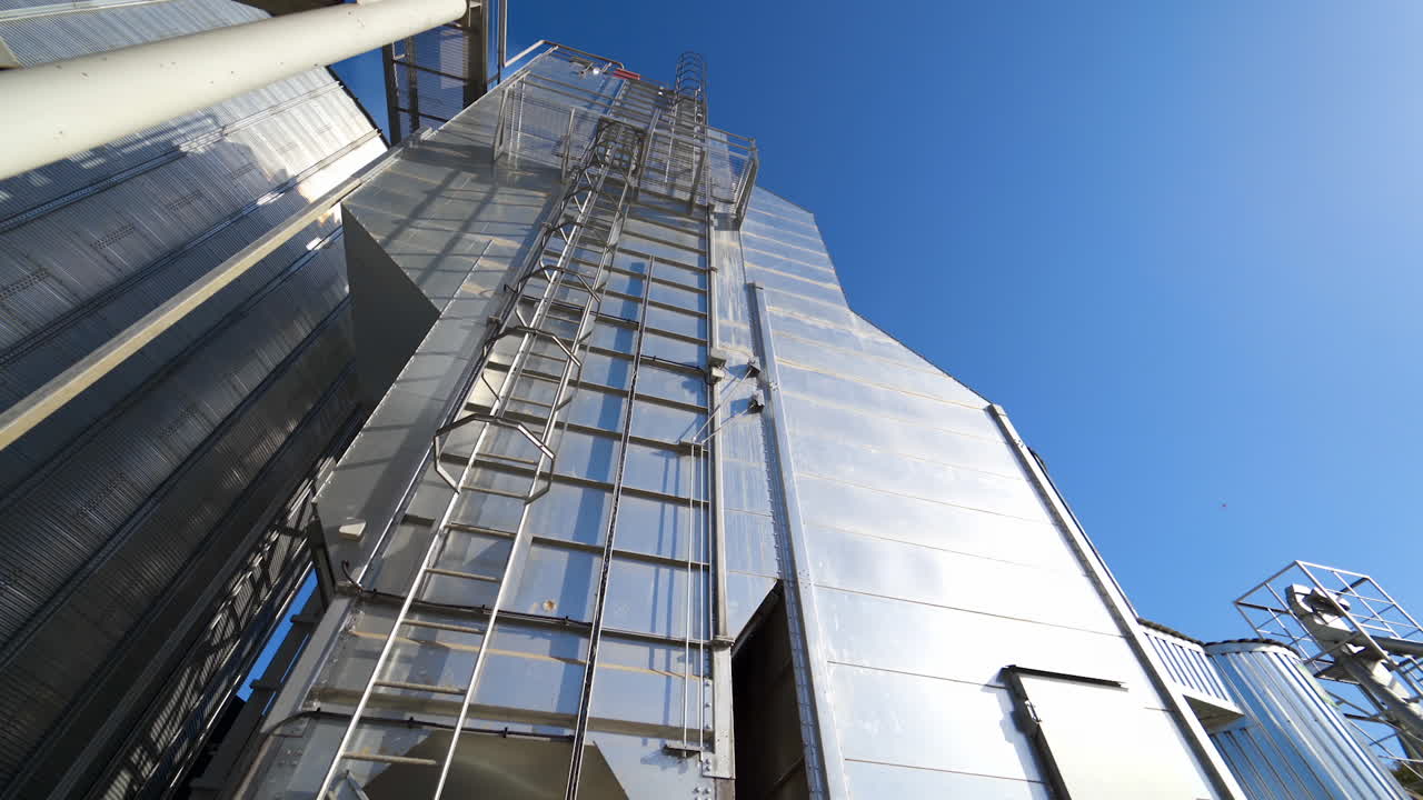 Sezione industriale di uno stabilimento illuminata dal sole. Moderno impianto industriale su sfondo di cielo blu. Esterno di un nuovo edificio per l'agroindustria