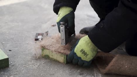 trabajador que utiliza una grapadora en el material de aislamiento