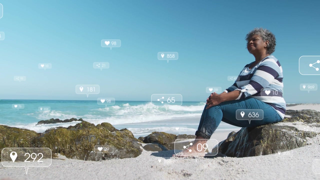 Camera holding woman sitting gazing ocean resting, social media icons rising then fading over her