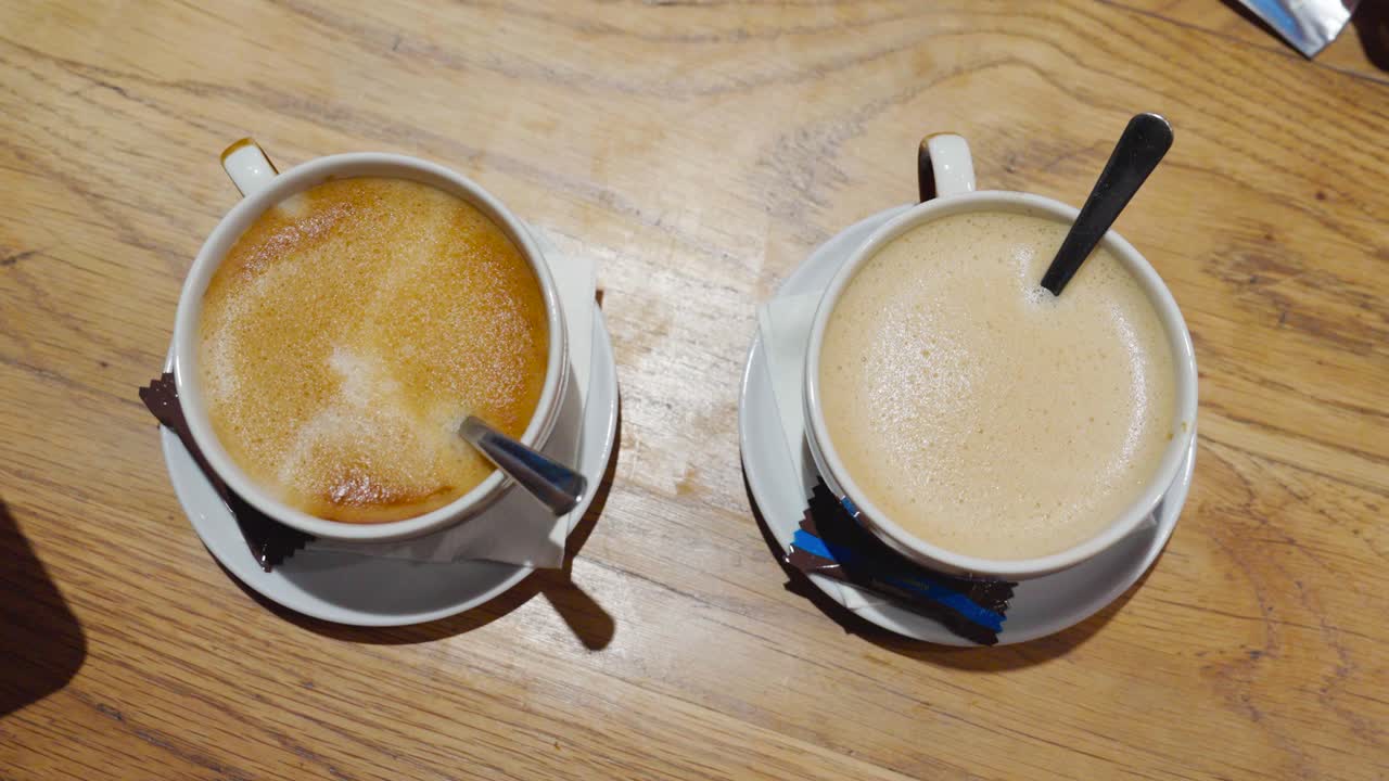 Primo piano dall'alto di due diverse bevande al caffè con caramelle - bianco e latte.