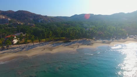 Eine-Nahaufnahme,-Die-An-Einem-Wunderschönen-Weißen-Sandstrand-Mit-Palmen-Und-Ruhigem-Türkisblauem-Wasser-Entlang-Der-Küste-Mexikos-Vorbeigleitet