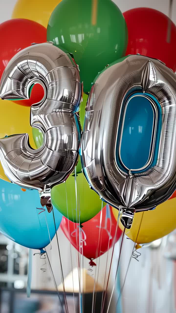 Vertical video: Nudging silver 3 and 0 foil balloons and latex inside party room by light air draft