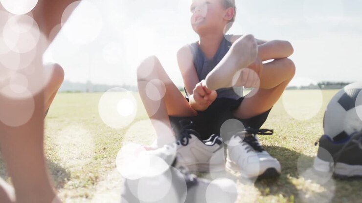 Animazione di punti luce su scolari felici e di diverse etnie che si cambiano le scarpe per una lezione di sport all'aperto