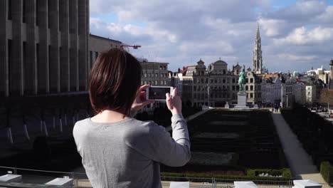una turista se toma fotos con su teléfono inteligente en bruselas, bélgica.