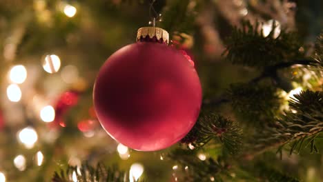 ornamento vermelho na árvore de natal com luzes de bokeh