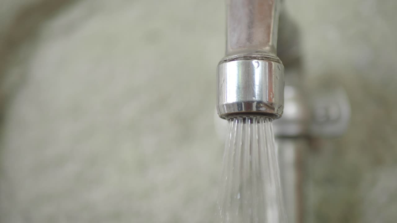 Close up of a faucet with water running