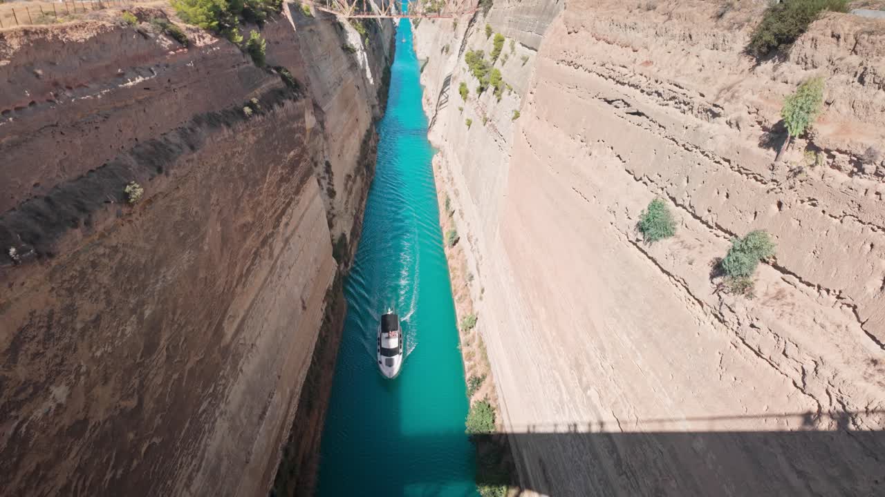 Boat navigates iconic narrow Corinth canal to Saronic Gulf Aegean Sea.