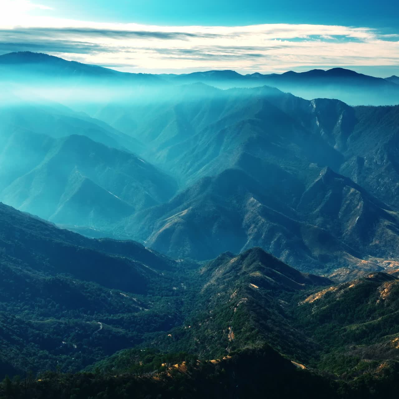 Mighty green mountains in California covered with blue mist. Splendid view of the rocks in blue haze from top