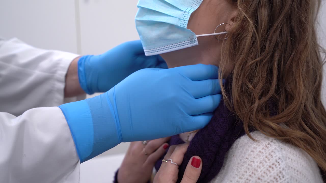 médico de cultivos examinando el cuello del paciente