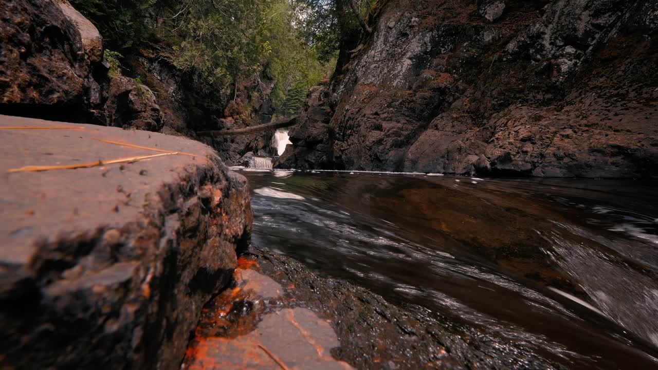 el río cascade fluye a través de un desfiladero rocoso en el bosque en el parque estatal del río cascade en minnesota.