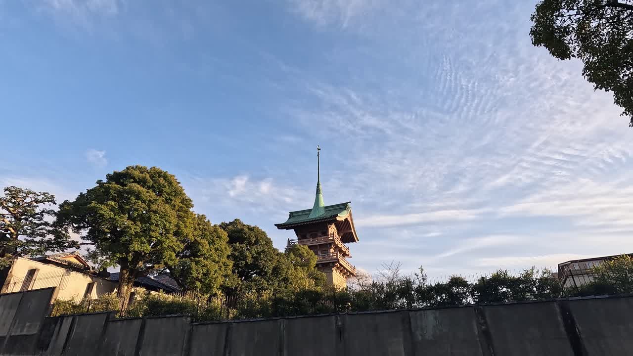 Daiun-in Gionkaku Temple Tower in Kyoto Framed by Green Trees and Dramatic Blue Sky at Sunset