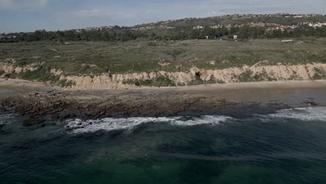 drone volando lejos de la playa de la costa del parque estatal de crystal cove