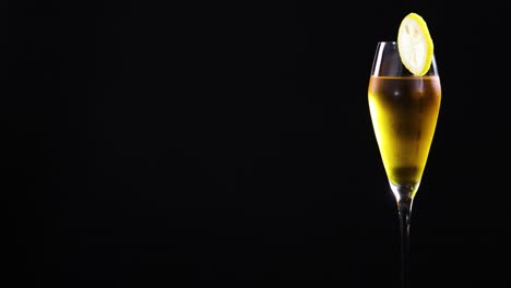 a lemon sour cocktail in a glass with lemon slice garnish, set against a black background, showcasing elegant simplicity