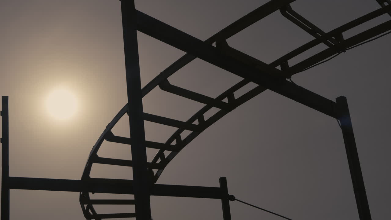 silueta de una vieja montaña rusa desvencijada que se acerca al atardecer