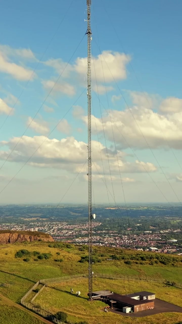 Video en primer plano invertido de la Torre Transmisora de Televisión de Black Mountain en Belfast Oeste, Irlanda del Norte, en una tarde luminosa, producido en 60FPS, relación social 1080x1920 y con color Rec709
