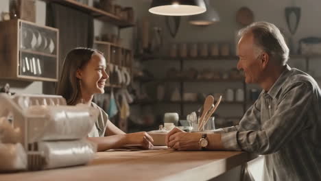 a young woman receives money from an older man at a cafe counter