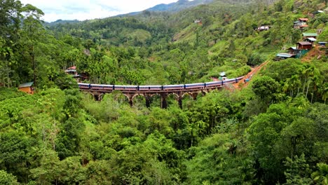 stunning aerial drone footage of a train crossing the iconic nine arches bridge in ella, sri lanka.
